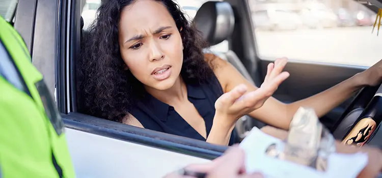 A photo of a female driver receiving a ticket.